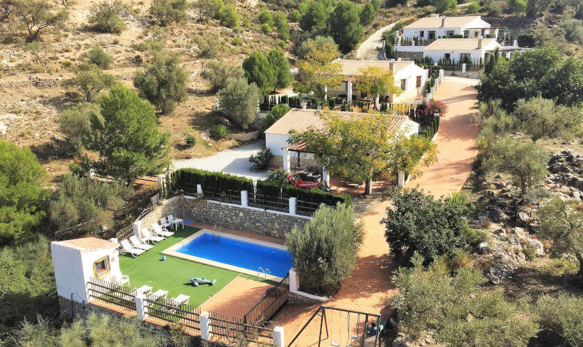  Drone view of Casa Lobero in the Axarquía countryside on several terraced levels with guest houses and swimming pool.