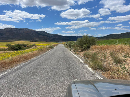 Die sonnige Landschaft Andalusiens mit einer kleinen Landstraße