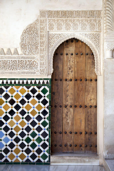 Verzierte Tür in der Alhambra de Granada mit maurischen Ornamenten und Kacheln