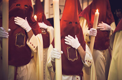 Foto van Castaleros met rode puntmutsen tijdens een optocht in Semana Santa