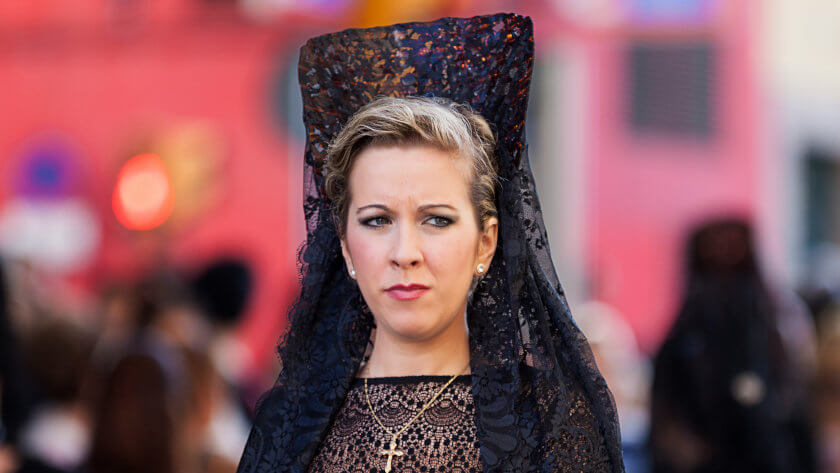 Een vrouw in zwarte feestkleding tijdens de Semana Santa in Velez-Malaga