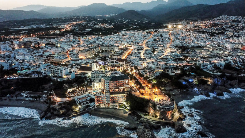 Nerja met verlichting in de late avond vanuit de lucht gezien