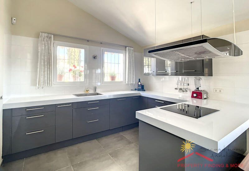Modern and fully equipped kitchen with two windows. 
