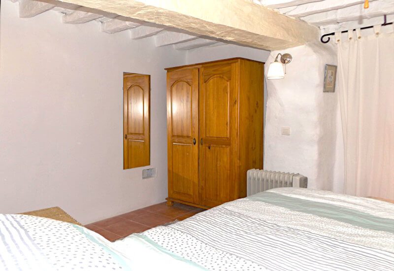 guest bedroom with wooden wardrobe and rustical wall