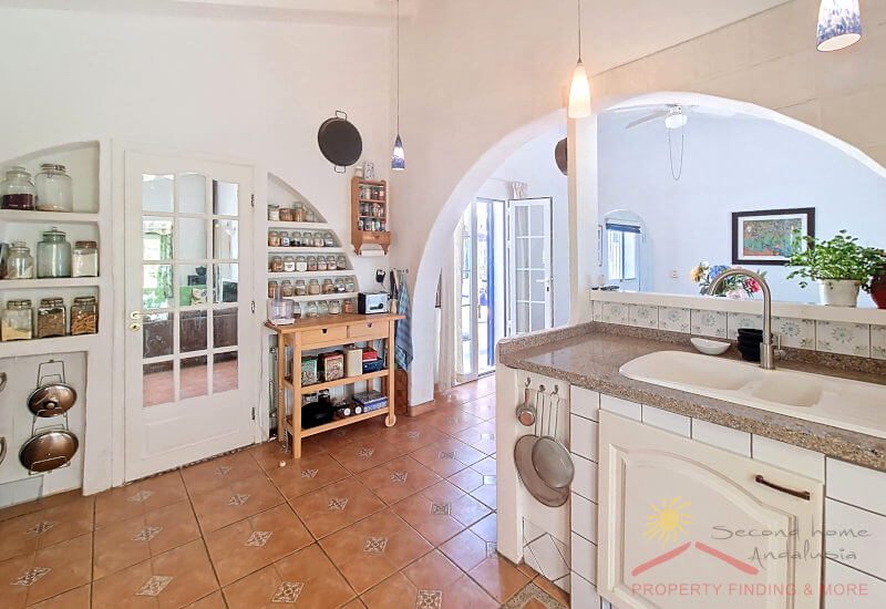Kitchen with open shelves, glass door to the living room and dining area in the open adjoining room