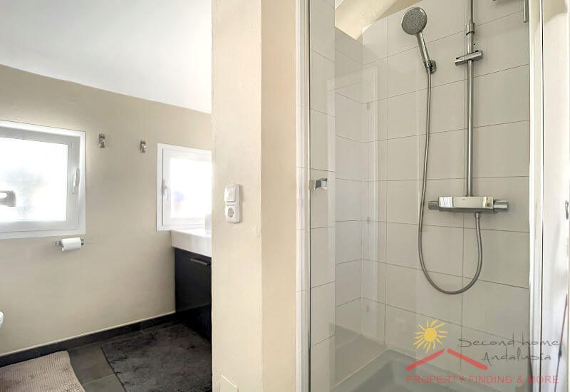 Modern bathroom in the old part of the building with shower and small windows