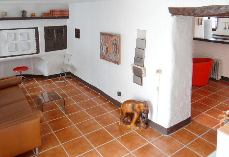Wohnzimmer mit Sitzecke und rustikalen Mauern in Canillas de Aceituno