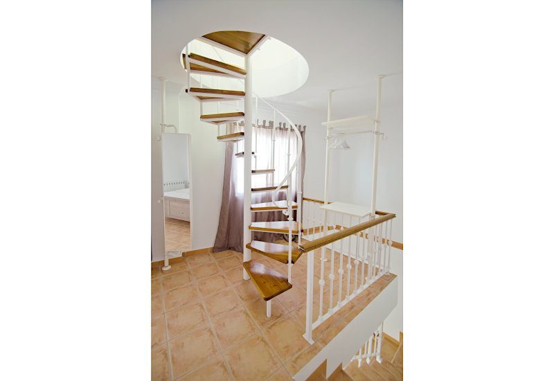 The two bedrooms are connected by an open spiral staircase