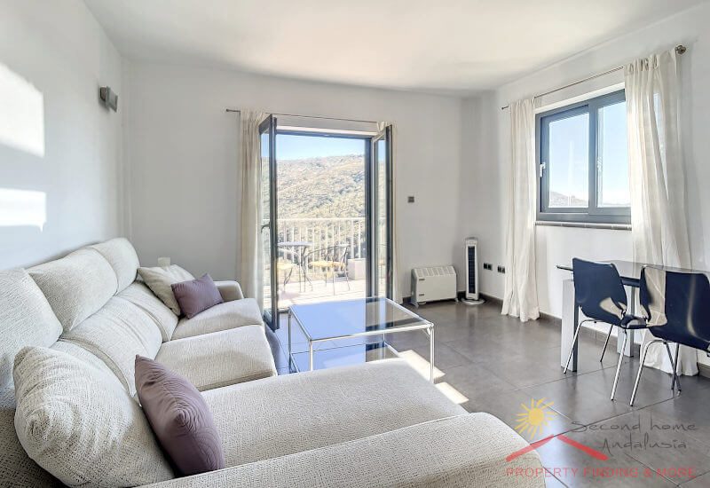 The apartment sitting area and dining table with open french door to the terrace