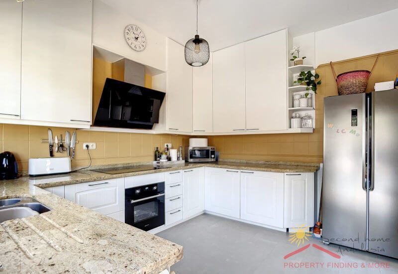 a big fully equipped modern kitchen with a window a terrace door