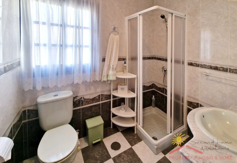Zweites Badezimmer mit Dusche, Toilette und Waschbecken, sowie großem Fenstern