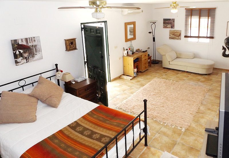 Lower studio with bed and lounge of Casa Montaña in Sedella