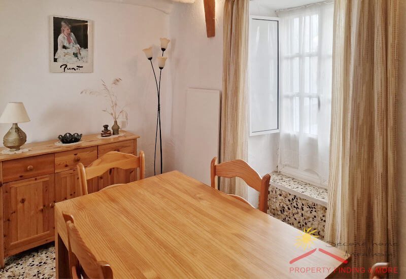 Dining room with table for four persons has a big window
