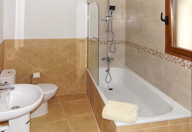 Gedeelde badkamer met buis en douche met veel ruimte