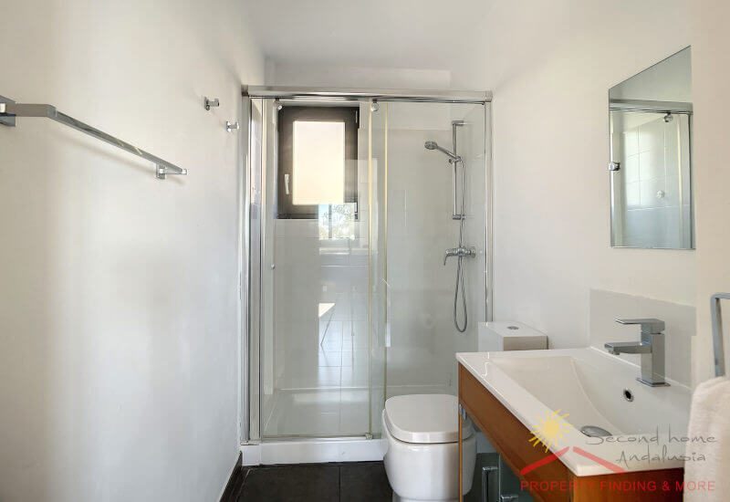 The apartment en-suite bathroom has a shower, toilette and a basin