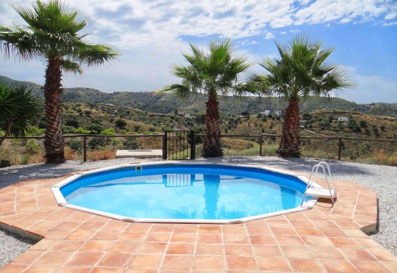 Rond zwembad van Casa Lisa te koop met palmen rondom en een geweldig uitzicht