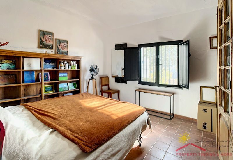 Brede slaapkamer begane grond met tweepersoonsbed, plank en raam