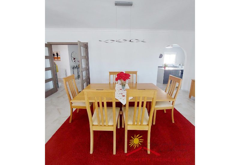 a big dining area with wooden table and access to the kitchen