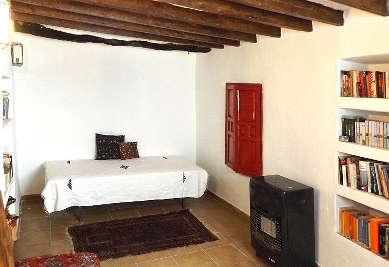 In the study house there is an additional bedroom shown here with shelves and a gas burner. A window brings natural light into it.
