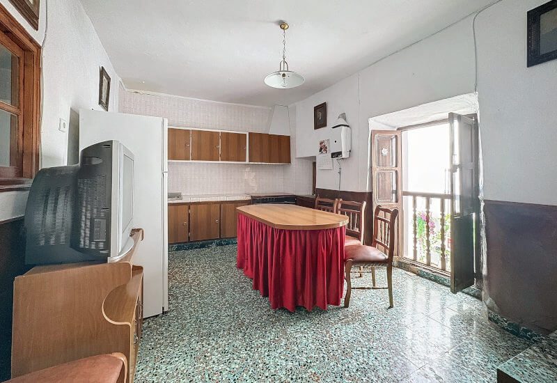 Eine große, traditionell eingerichtete Küche mit Doppeltür zur Straße hin