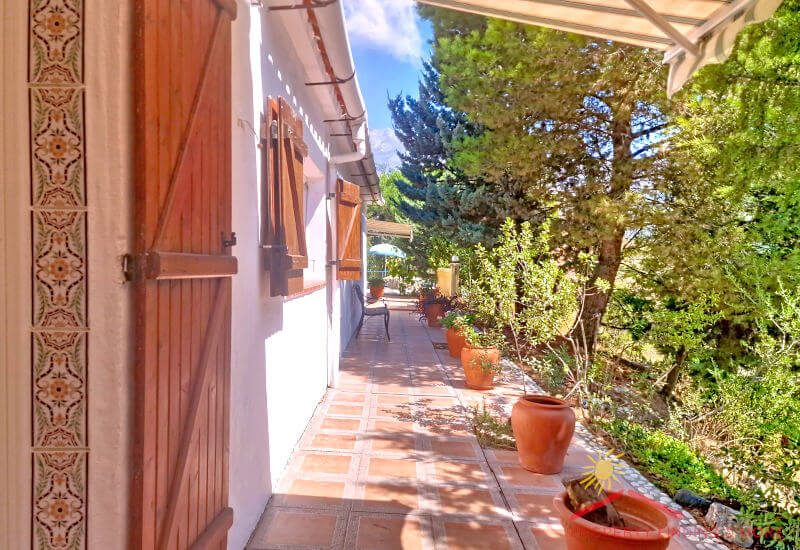 Back terrace of Casa Coppe in the sun with some pots and plants