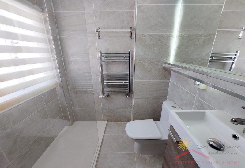 modernes en-suite Badezimmer mit Fenster, einer Dusche und einer Toilette