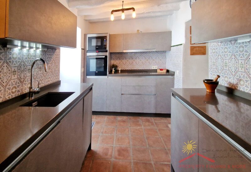 Photo of fully equipped kitchen with glass door to the garden.