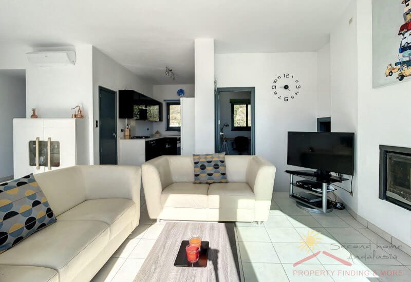 Lounge with nice sofa area and a chimnea. Open to the kitchen in the back.