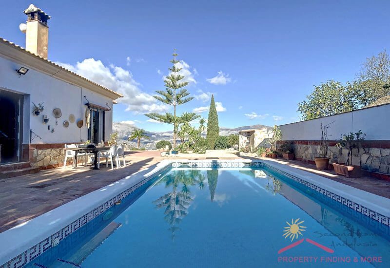 Een beschermd zwembad met terras ligt naast het huis met een mooi uitzicht over het landschap