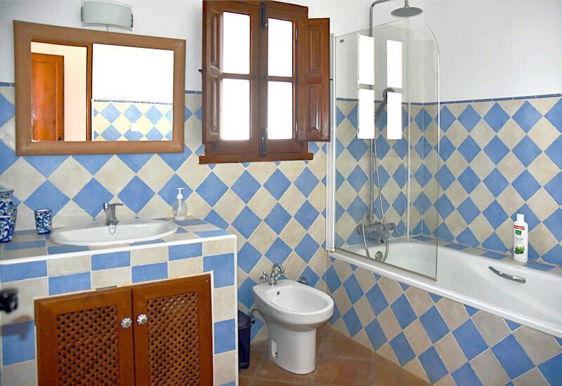 Badezimmer 3 mit Badewanne kombiniert mit Dusche, Toilette und einem kleinen Fenster