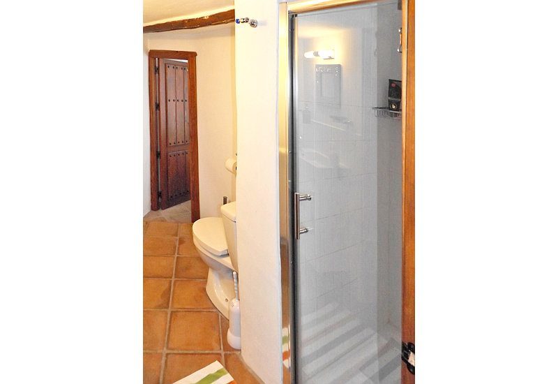 De ensuite badkamer heeft een moderne douche met glazen deur