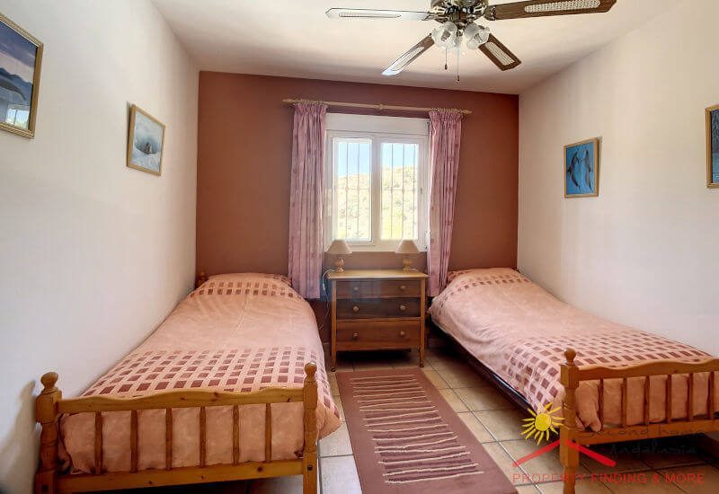 Het appartement slaapkamer 1 heeft een twin bed , plafond ventilator en een raam