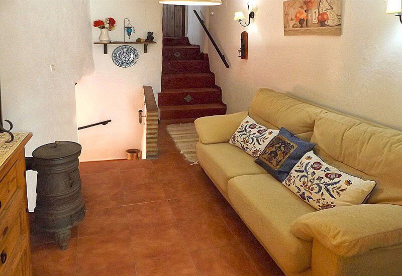 Foto des Empfangszimmers mit Sofa und Holzofen mit schöner Beleuchtung und Treppenauf- und -abgängen