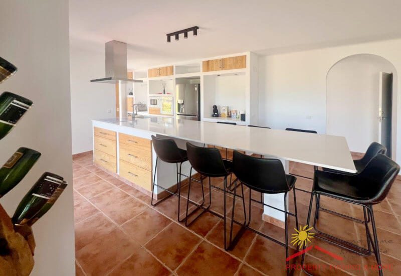 Moderne ingerichte keuken met kookeiland en eettafel voor 7 personen