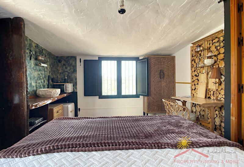 Traditioneel raam in de bovenste slaapkamer, die ook een rustiek plafond heeft
