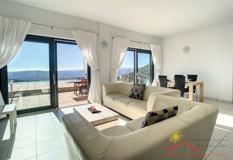 The lounge is flooded with light through two big glass terrace doors