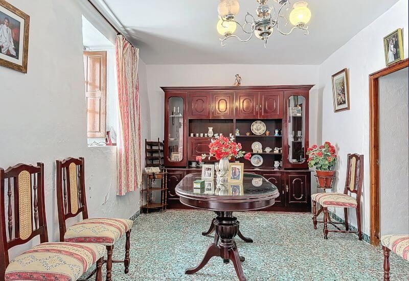 Traditionelles Wohnzimmer mit einem Fenster, einigen Stühlen, einem Tisch und einem Hängeschrank