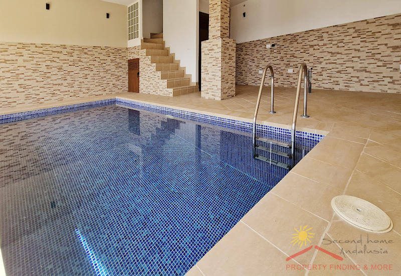 A staircase leads to the swimming pool room