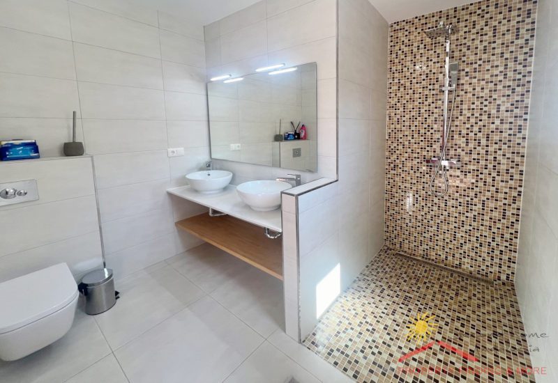 De badkamer van de twin gastenkamer met douche en 2 wastafels