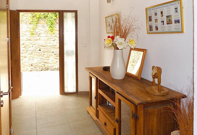 You enter the entrance hall through a wide door with a side window