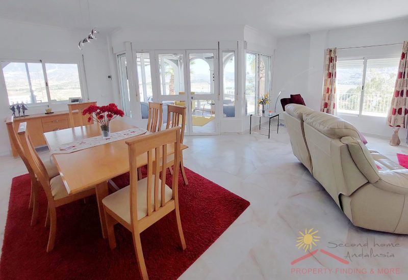 Die Lounge verfügt über verschiedene Bereiche, einige Fenster und einen Eingang mit Glastür