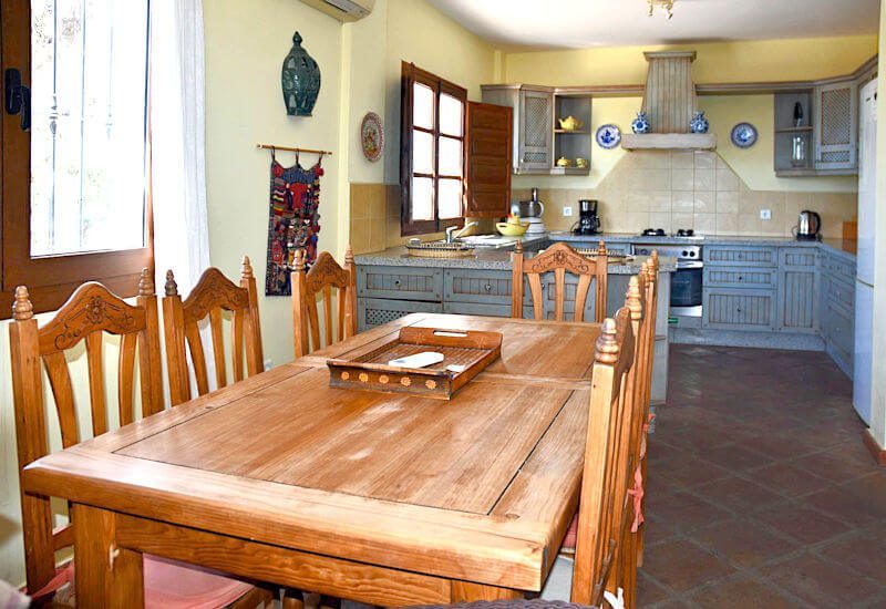 großer Esstisch mit offener Küche im hinteren Bereich