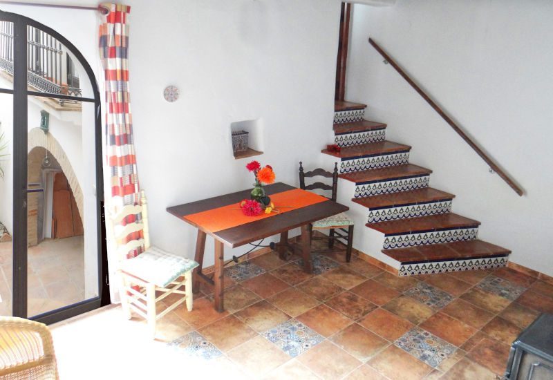 kleine lounge met tafel en trap naar de bovenverdieping