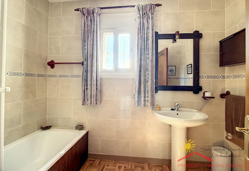 das Gästebad hat ein kleines Fenster und eine Röhre