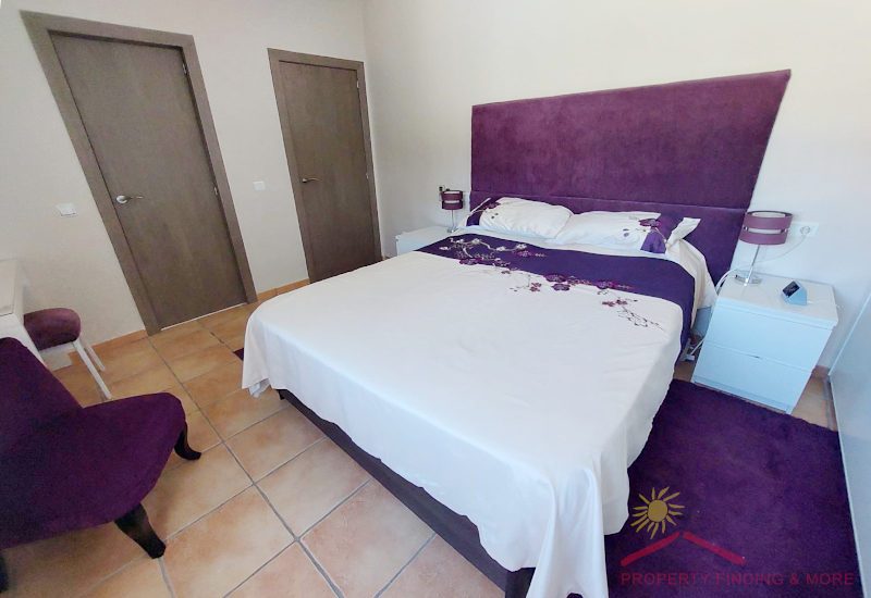 moderne slaapkamer met tweepersoonsbed en schuin paars met een en-suite badkamer