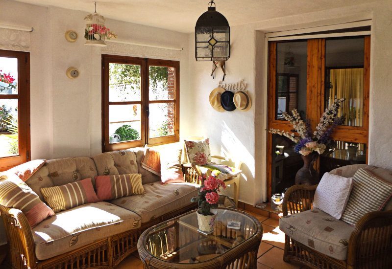 Zon lounge van Finca de Arriba met een zithoek en twee grote ramen.