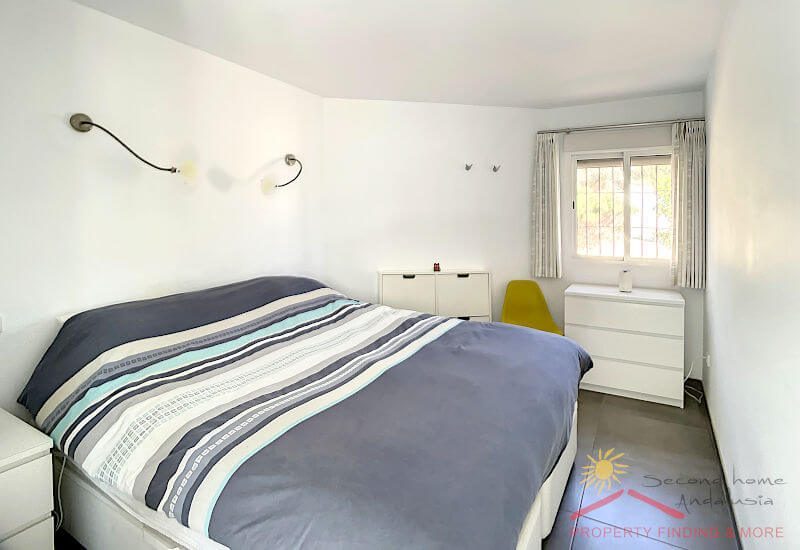 Slaapkamer met breed bed en raam