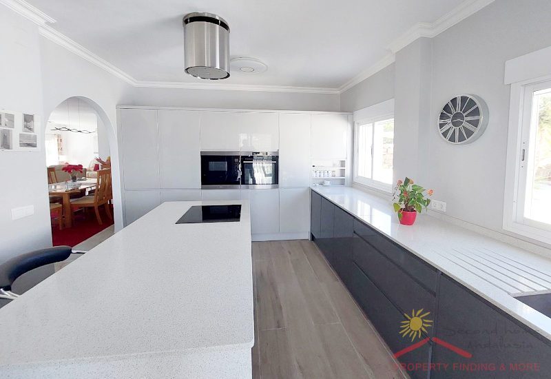 a large, modern, fully equipped kitchen with plenty of storage space and wide access to the living area
