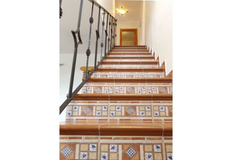 Een mooi betegelde trap leidt naar de eerste verdieping.