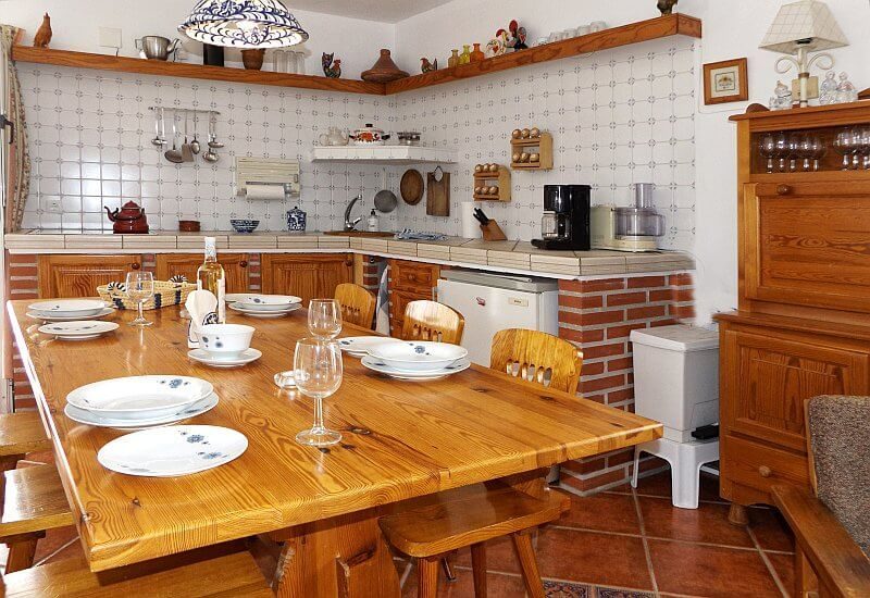 Ein großer Tisch im Wohn- und Esszimmer mit rustikaler Küche